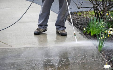 man washing off dirt. Person uses power washer, spring cleaning